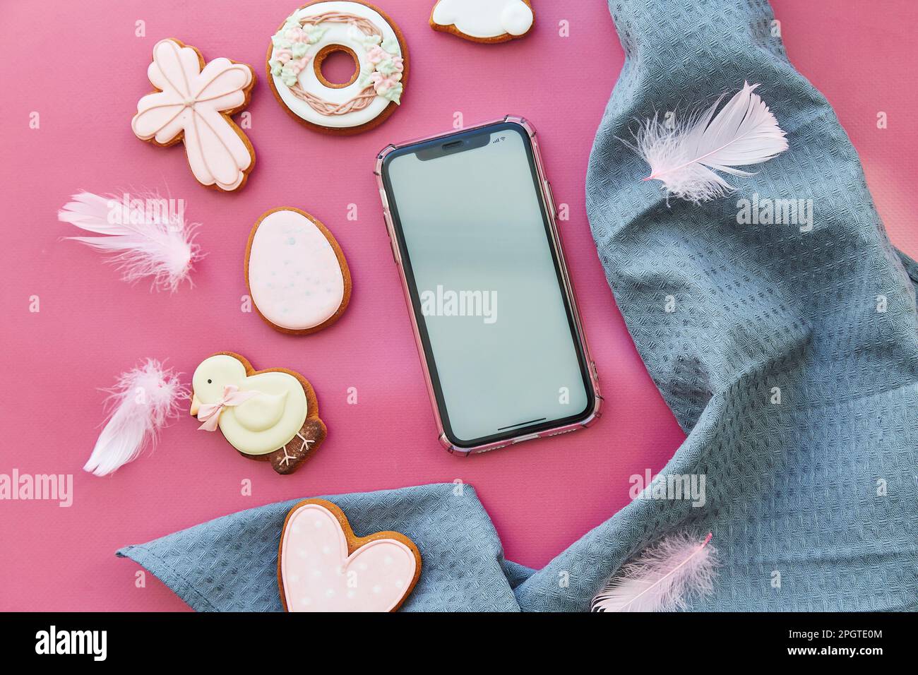 Easter aesthetics cookies and mockup of screen phone on pink background flat lay. Happy Easter. Stock Photo