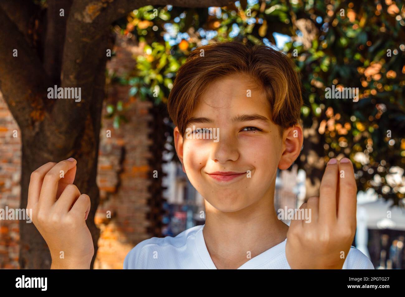 Teenage boy doing italian gestures with his hands and smiling under the