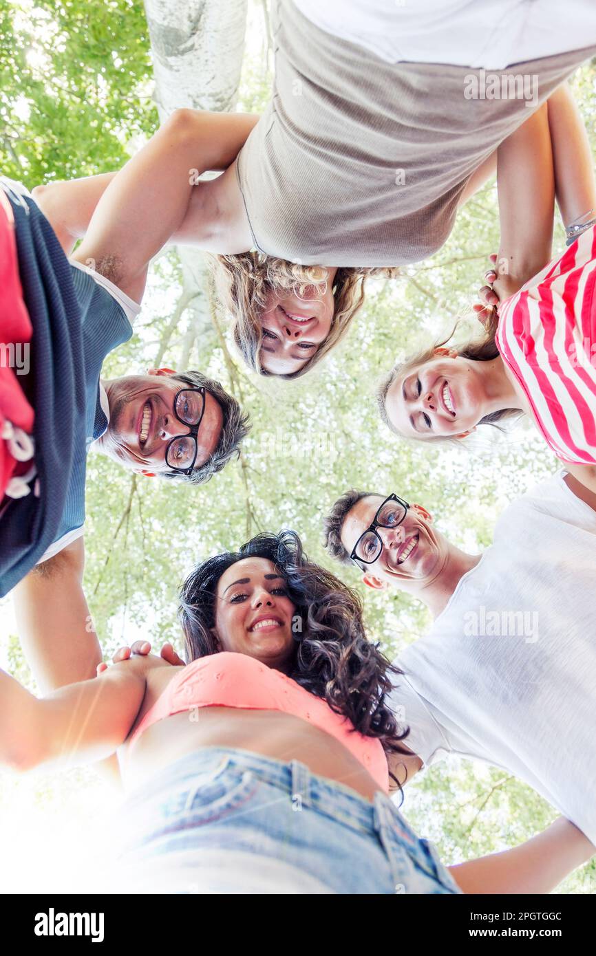 Group portrait of diverse young women wearing clothes in hipster style  looking at each other with smiles and hugging together stock photo