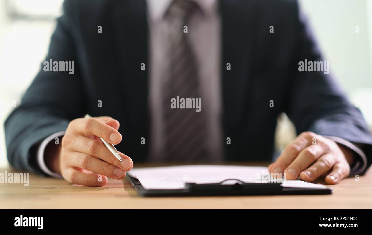 Businessman studying information on document before signing at work in office closeup Stock Photo