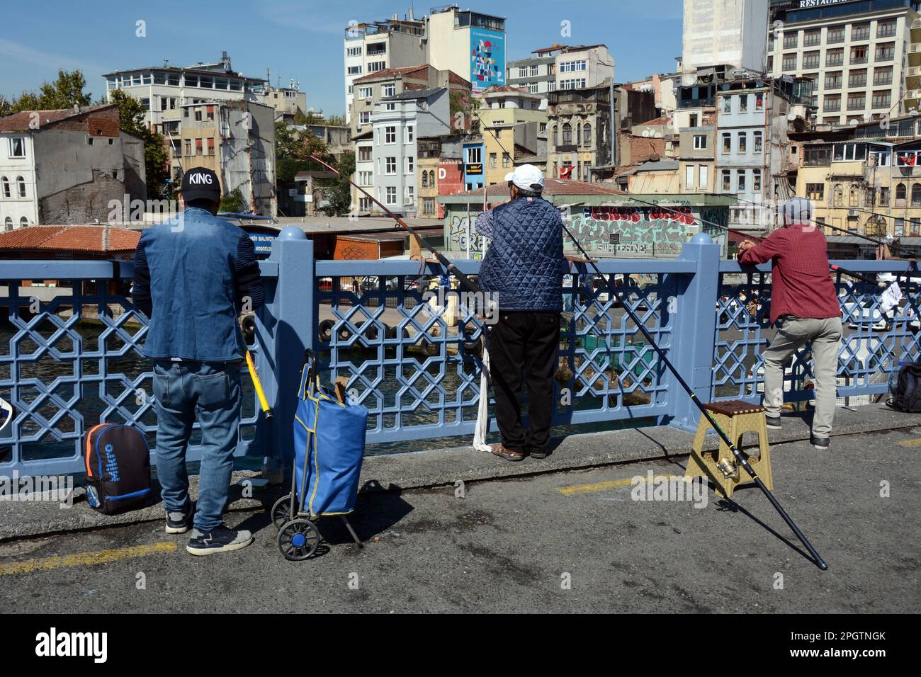 Fishermen fishing on the Galata Bridge where the Golden Horn meets the Strait of Bosphorus, Karakoy, Beyoglu, Istanbul, Turkey / Turkiye. Stock Photo