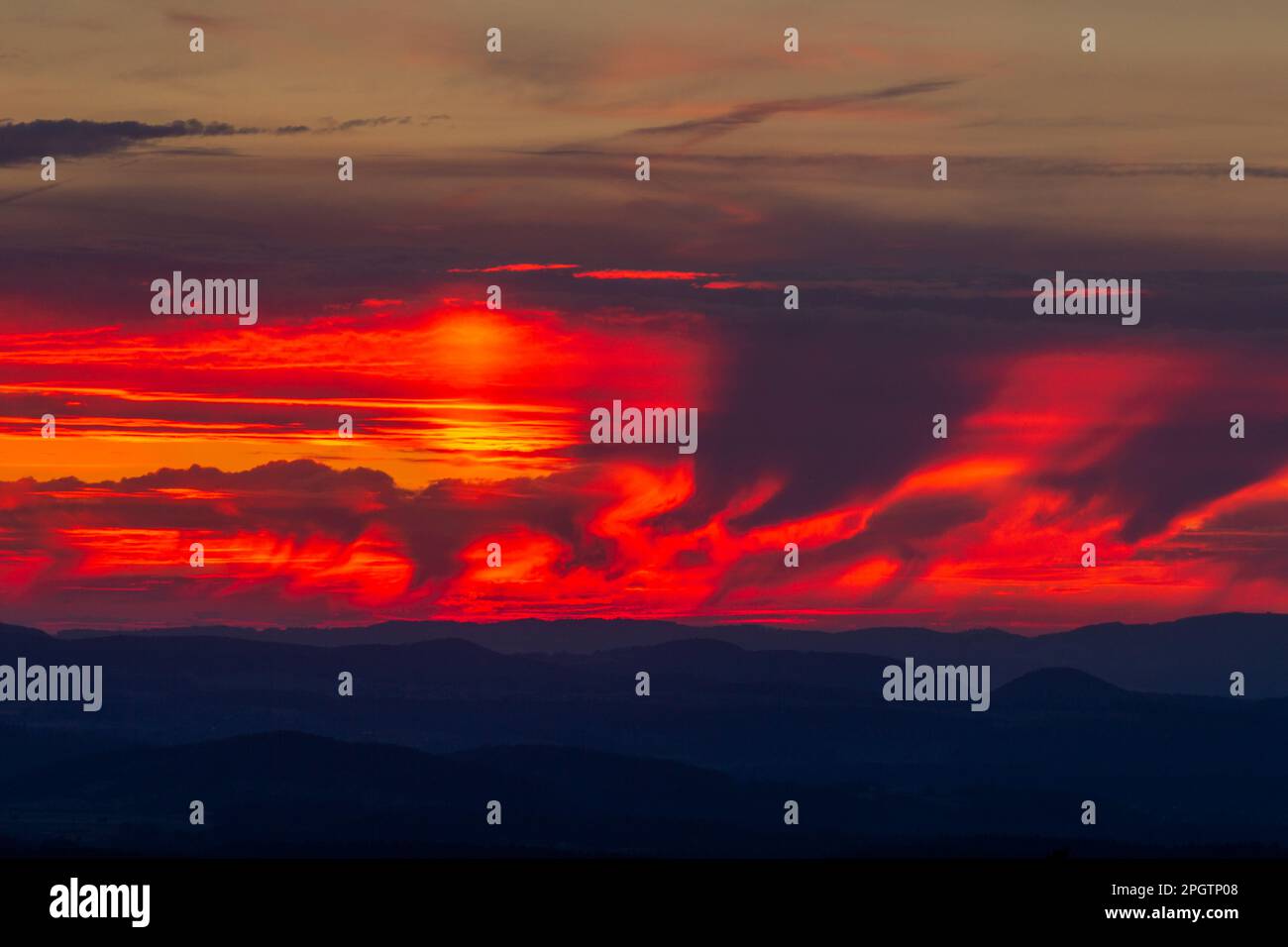Cloudy sky at dawn. Cloud formations lit by the vibrant colours of the