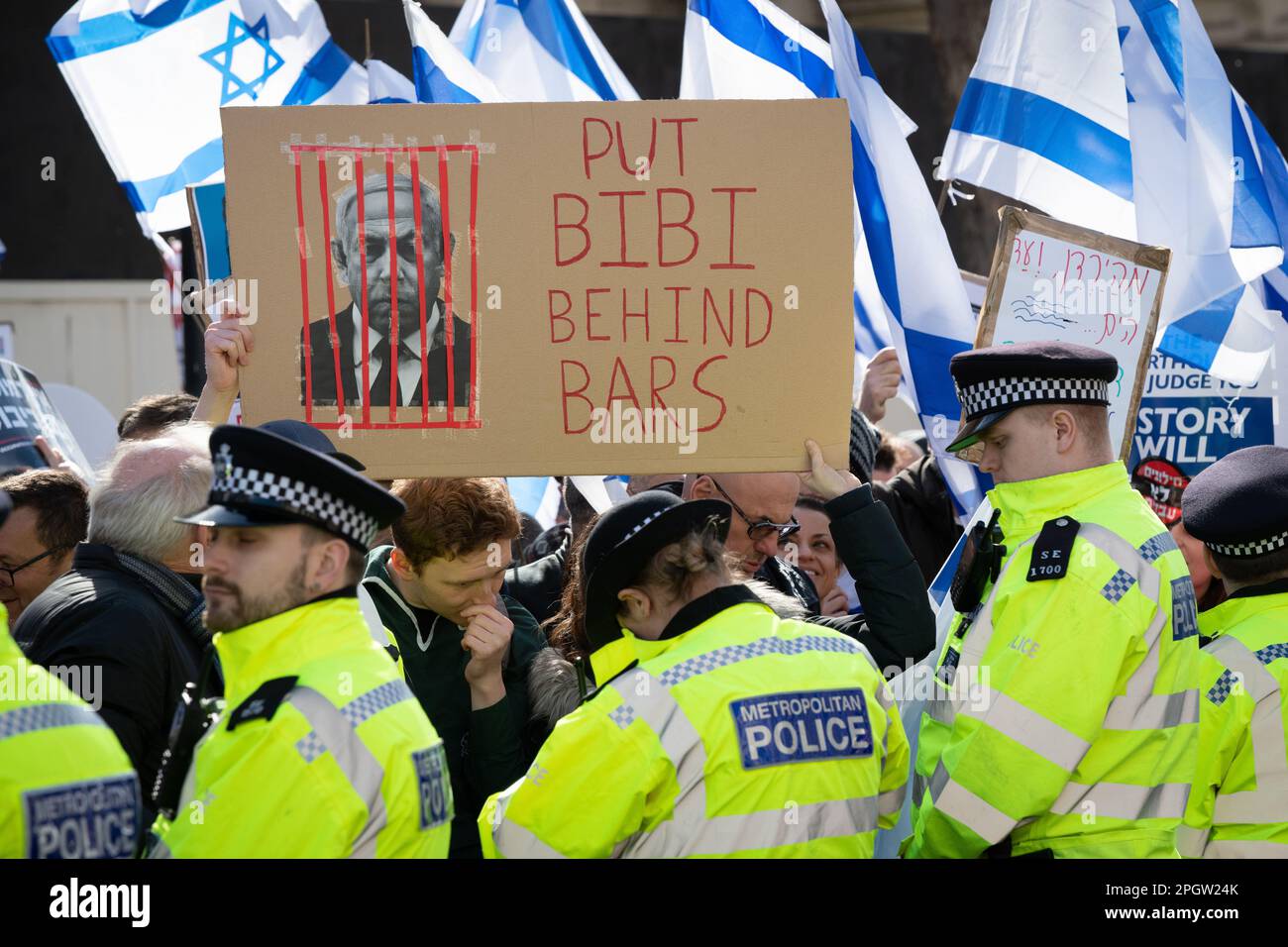 A protester holds a placard saying 'Put Bibi Behind Bars' during a protest in Whitehall against Israeli Prime Minister Benjamin Netanyahu as he visits Stock Photo