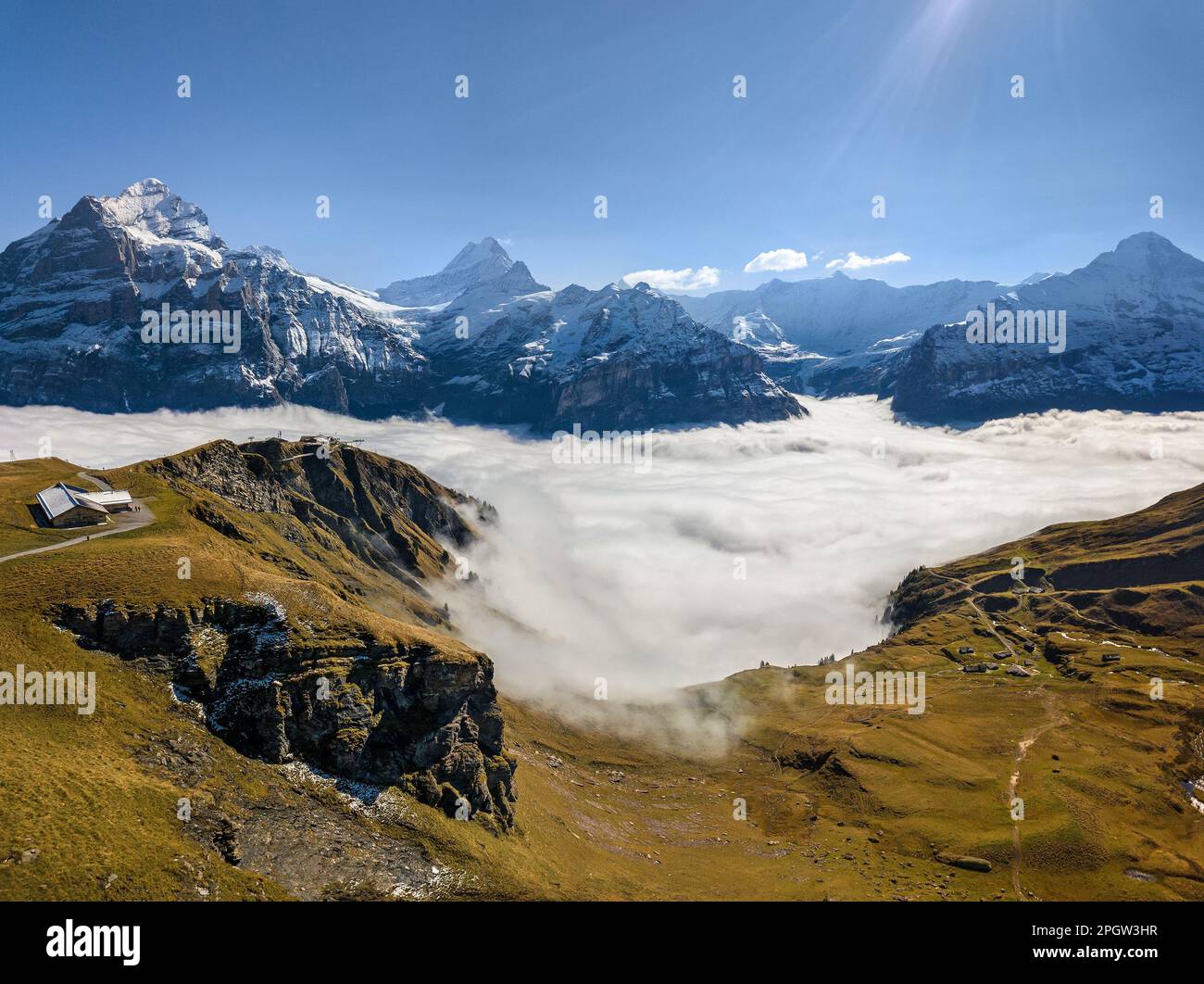 Fog rising over the First peak above Grindelwald with background of Wetterhorn, Schreckhorn and Eiger, Moench Alps mountain ranges Stock Photo