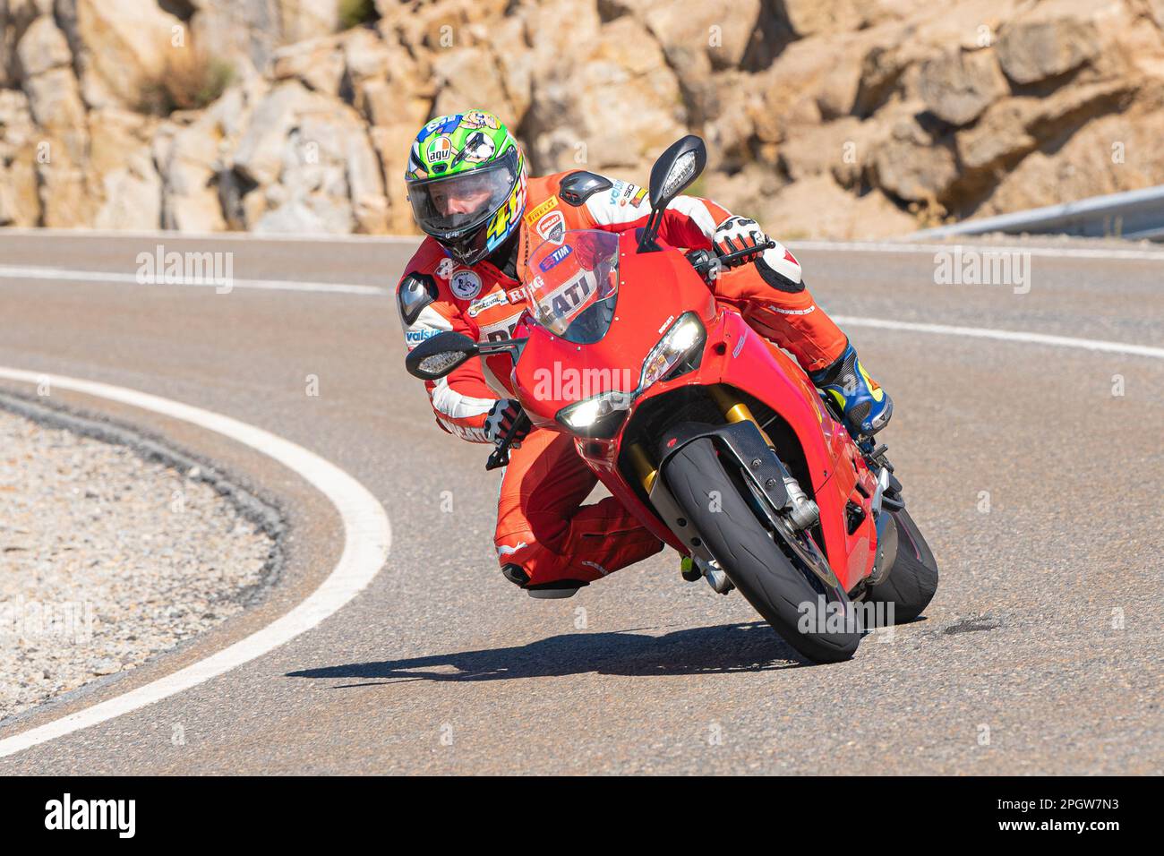 Rider on the asphalt with his bike leaning around a curve Stock Photo