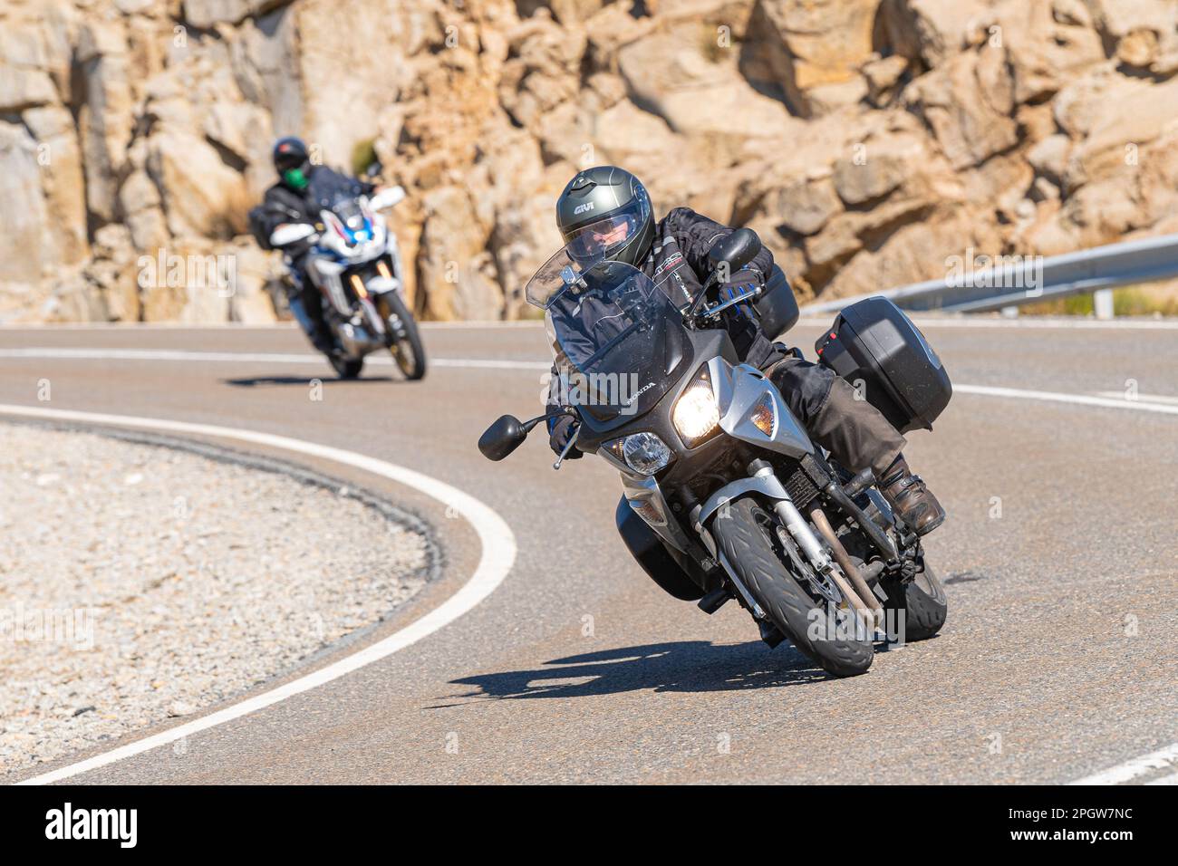 Rider on the asphalt with his bike leaning around a curve Stock Photo ...