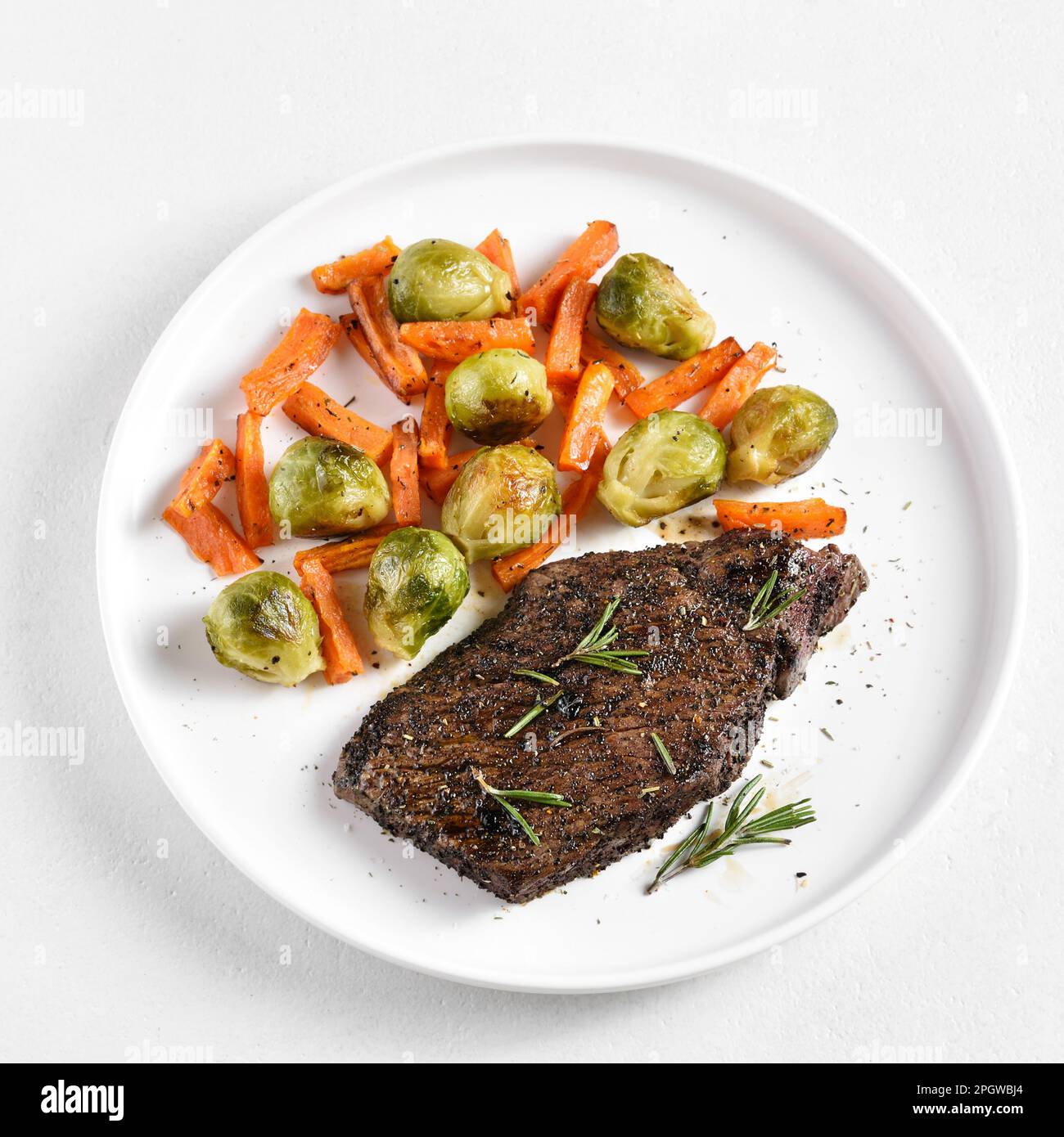 Grilled beef steak with brussels sprouts and sweet potatoes on plate