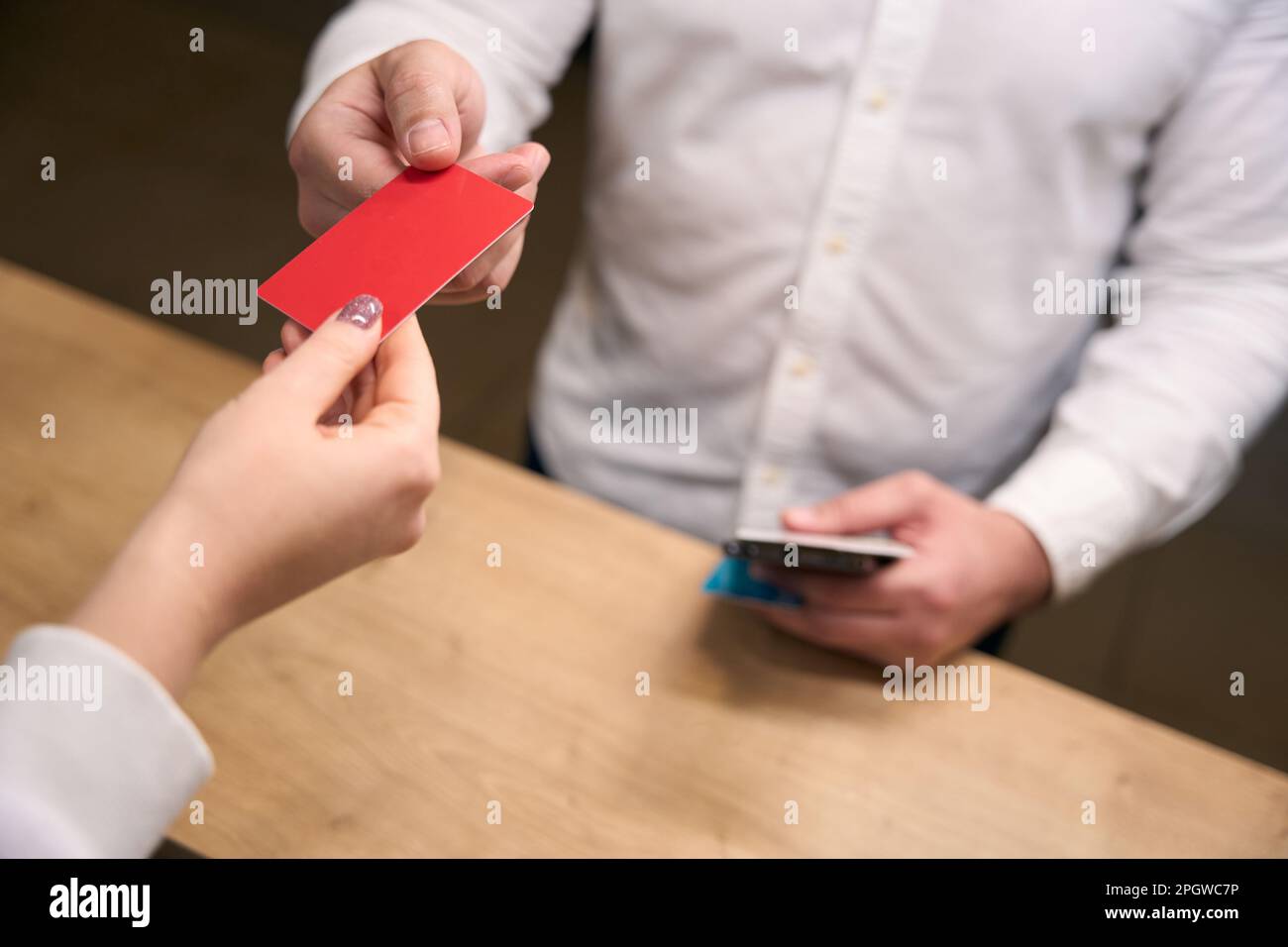 Businessperson getting key card from female receptionist Stock Photo