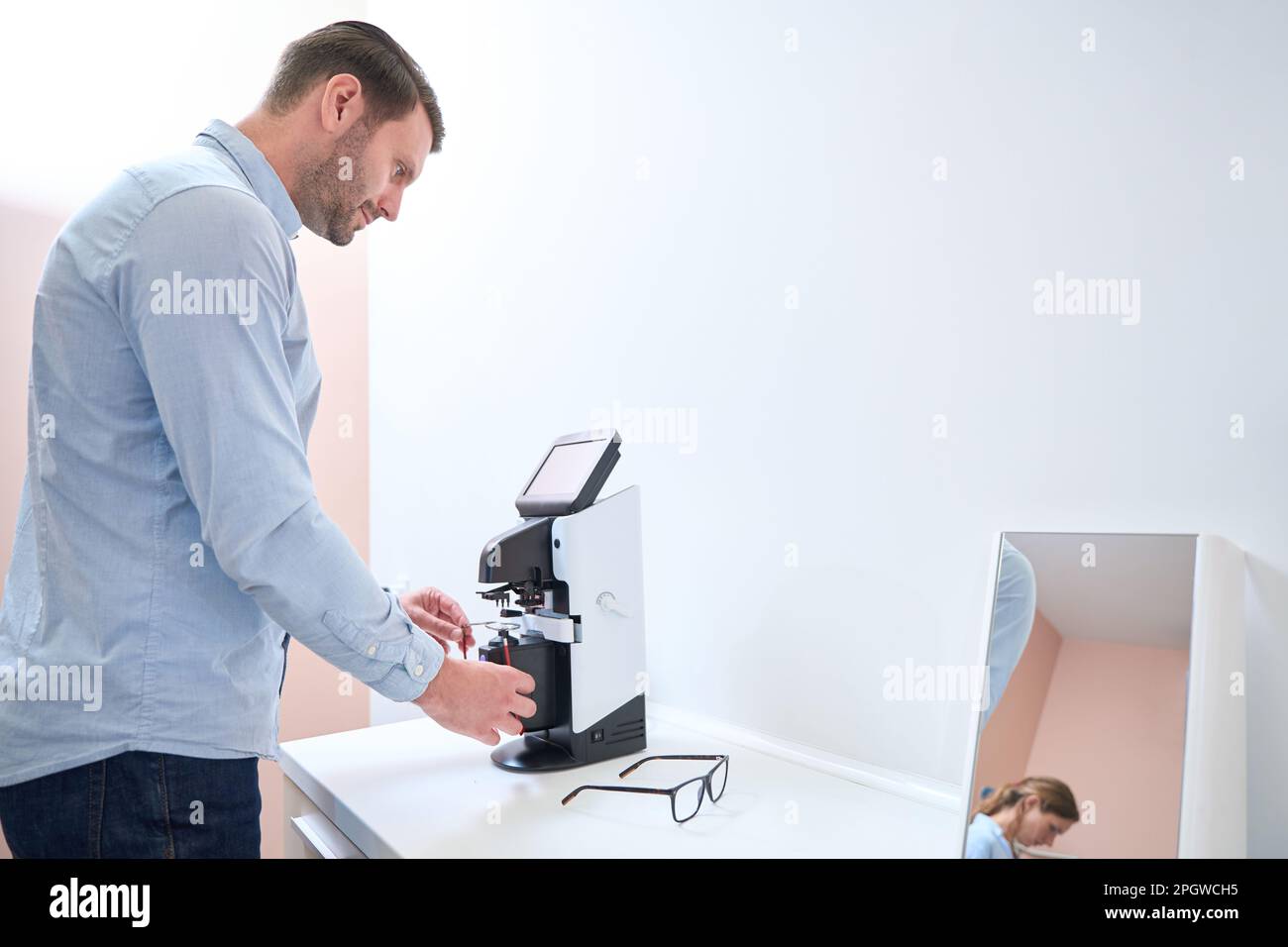 Qualified doctor is installing lenses on the frame in the ophthalmology ...