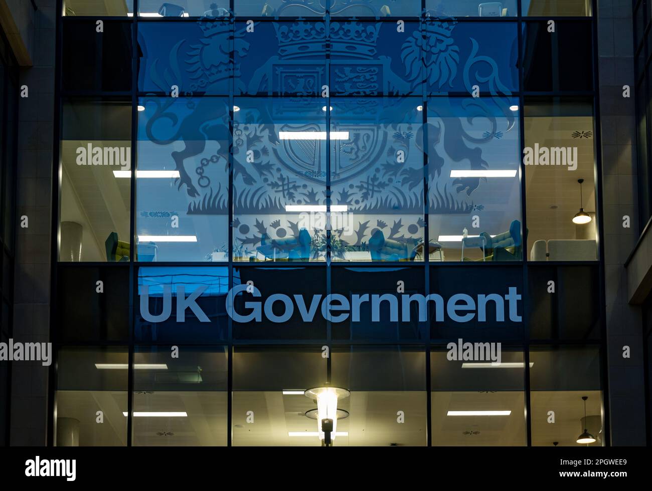 UK Government office building windows lit up at night with coat of arms, Edinburgh, Scotland, UK Stock Photo