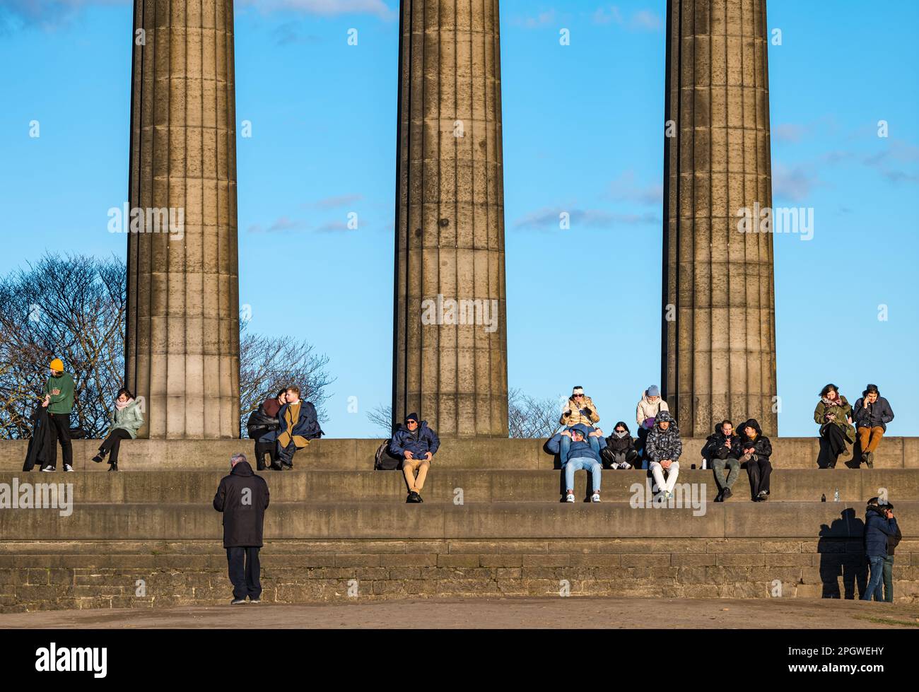Tourists sitting on the National Monument, Calton Hill, Edinburgh, Scotland, UK Stock Photo