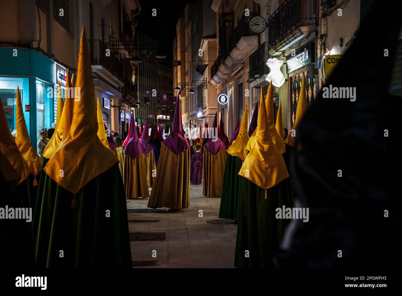 Gandia, Spain -  16 April 2022: Easter procession with colorful hooded people at night at Good Friday Stock Photo