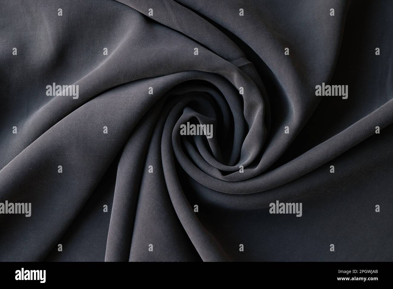 Rolled dark grey fabric sample in textile store or atelier Stock Photo