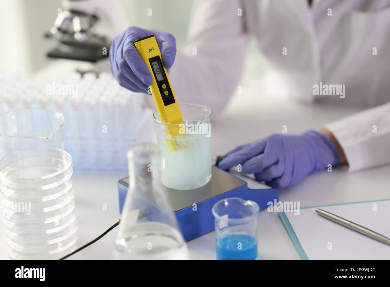 Specialist examines liquid in glassware using equipment Stock Photo