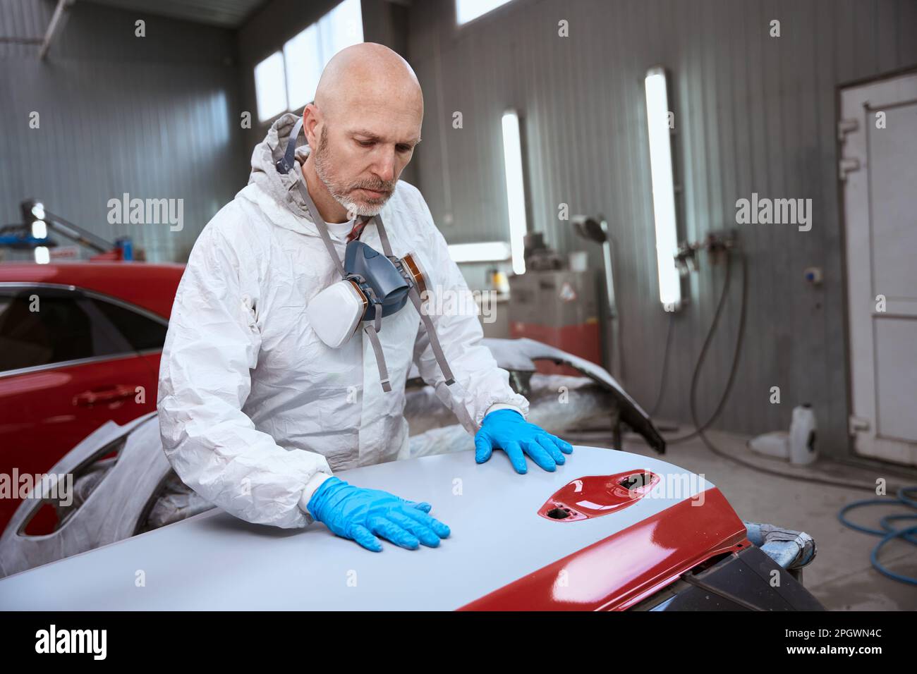 Auto repair shop worker working with unpainted car bumper Stock Photo
