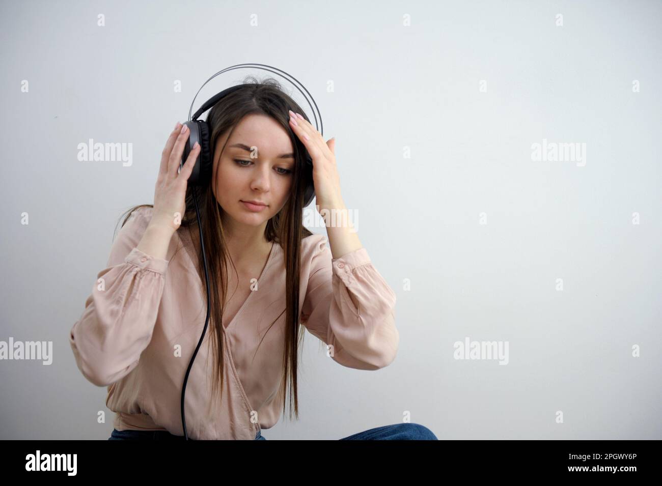 Girl in black headphones listening to music. Music lover woman is