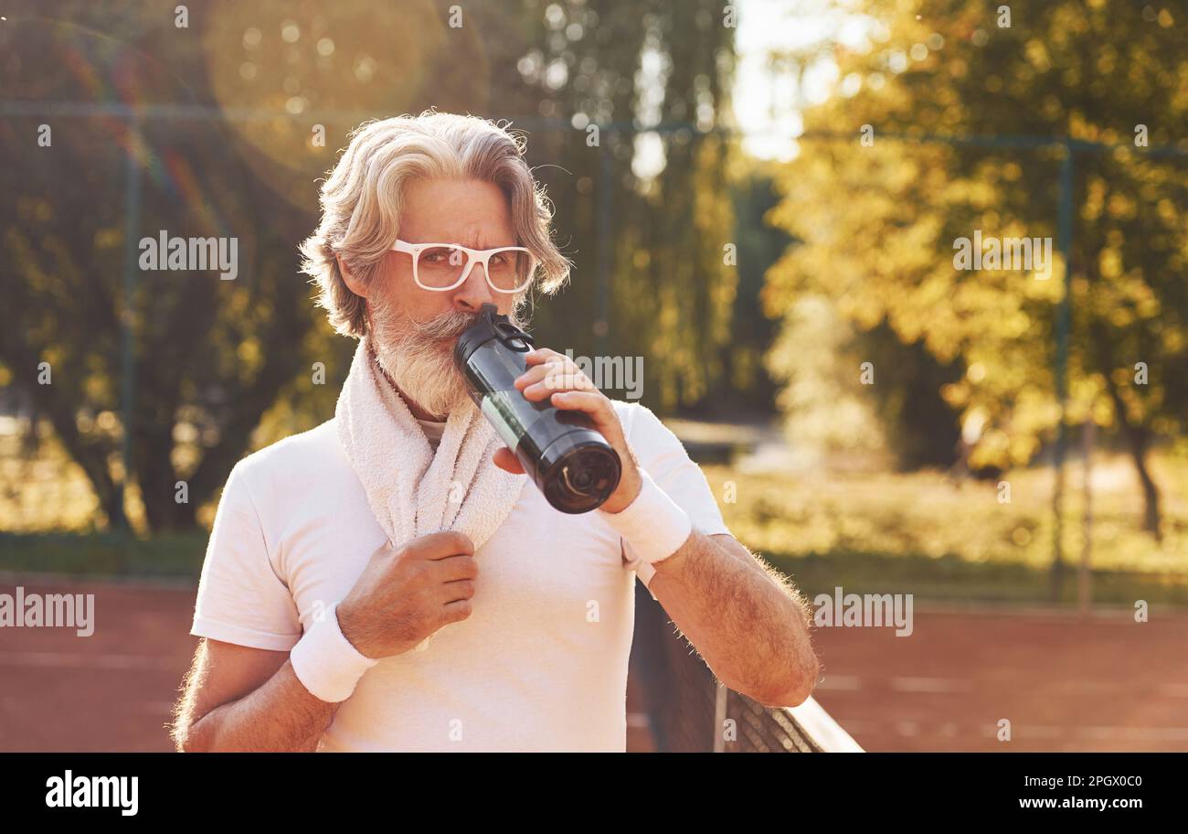 Taking a break and drinking water. Young sportive strong man in