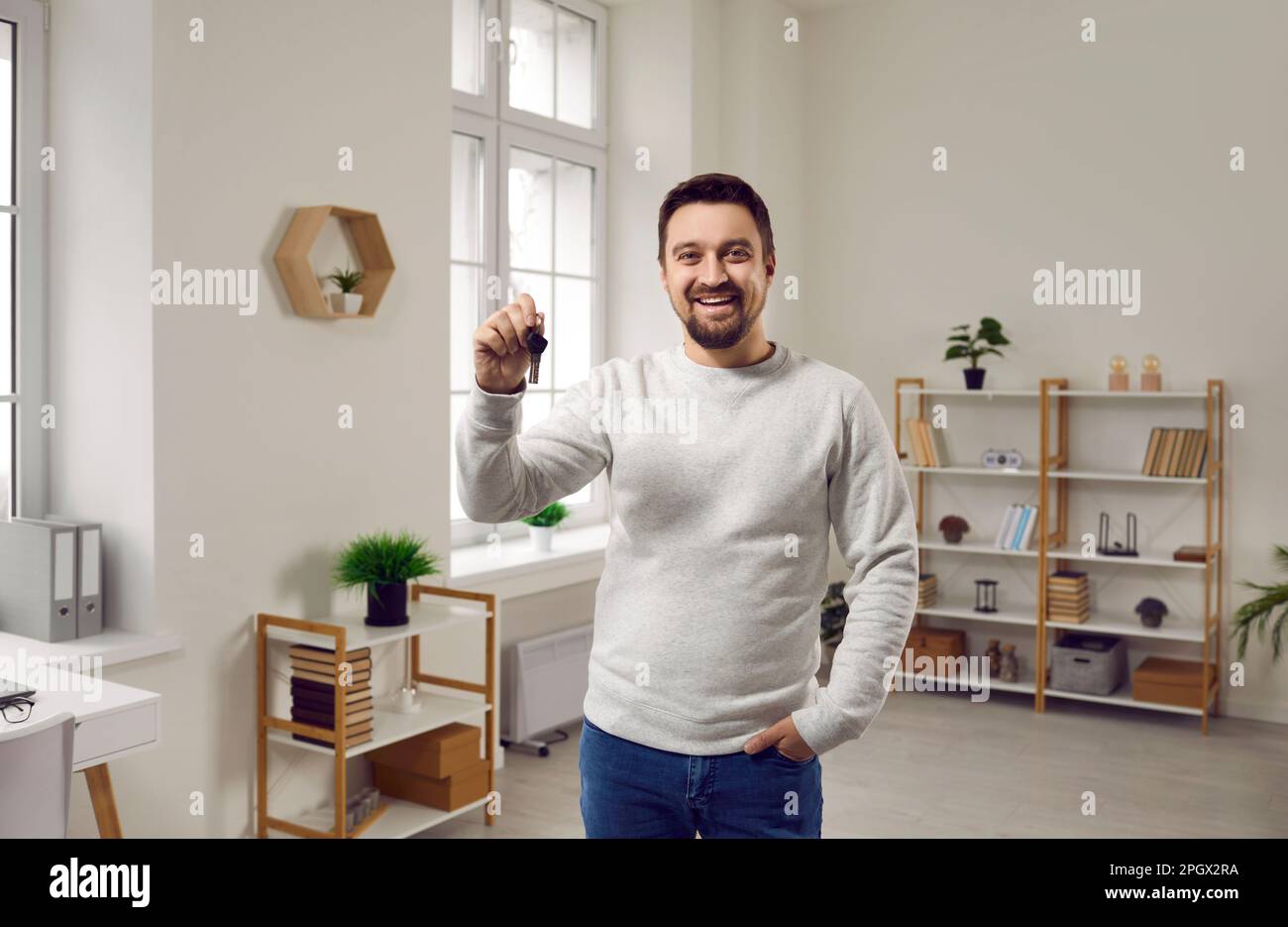 Happy young man holding keys to his new apartment Stock Photo - Alamy