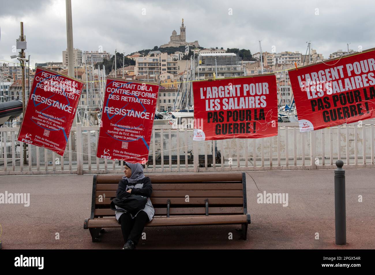 Marseille, France. 23rd Mar, 2023. Posters of the French Communist Party (PCF) seen on the Vieux-Port with the basilica of Notre Dame de la Garde in the background during the demonstration. The march against the pension reform project mobilized between 16000 (Police) and 280 000 normal demonstrators in Marseille. (Photo by Laurent Coust/SOPA Images/Sipa USA) Credit: Sipa USA/Alamy Live News Stock Photo