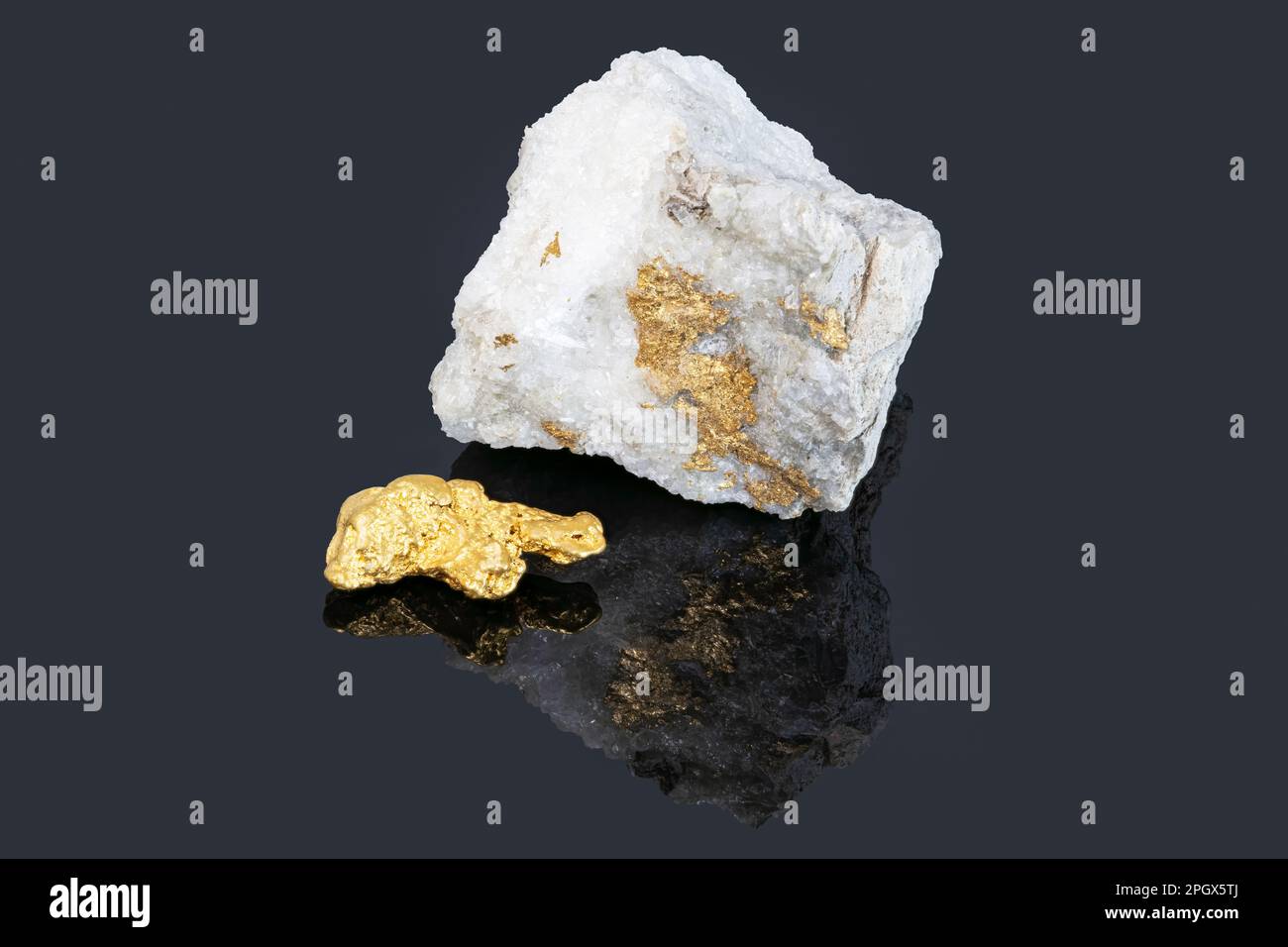 Gold on quartz and gold nugget on dark grey, reflective background Stock Photo