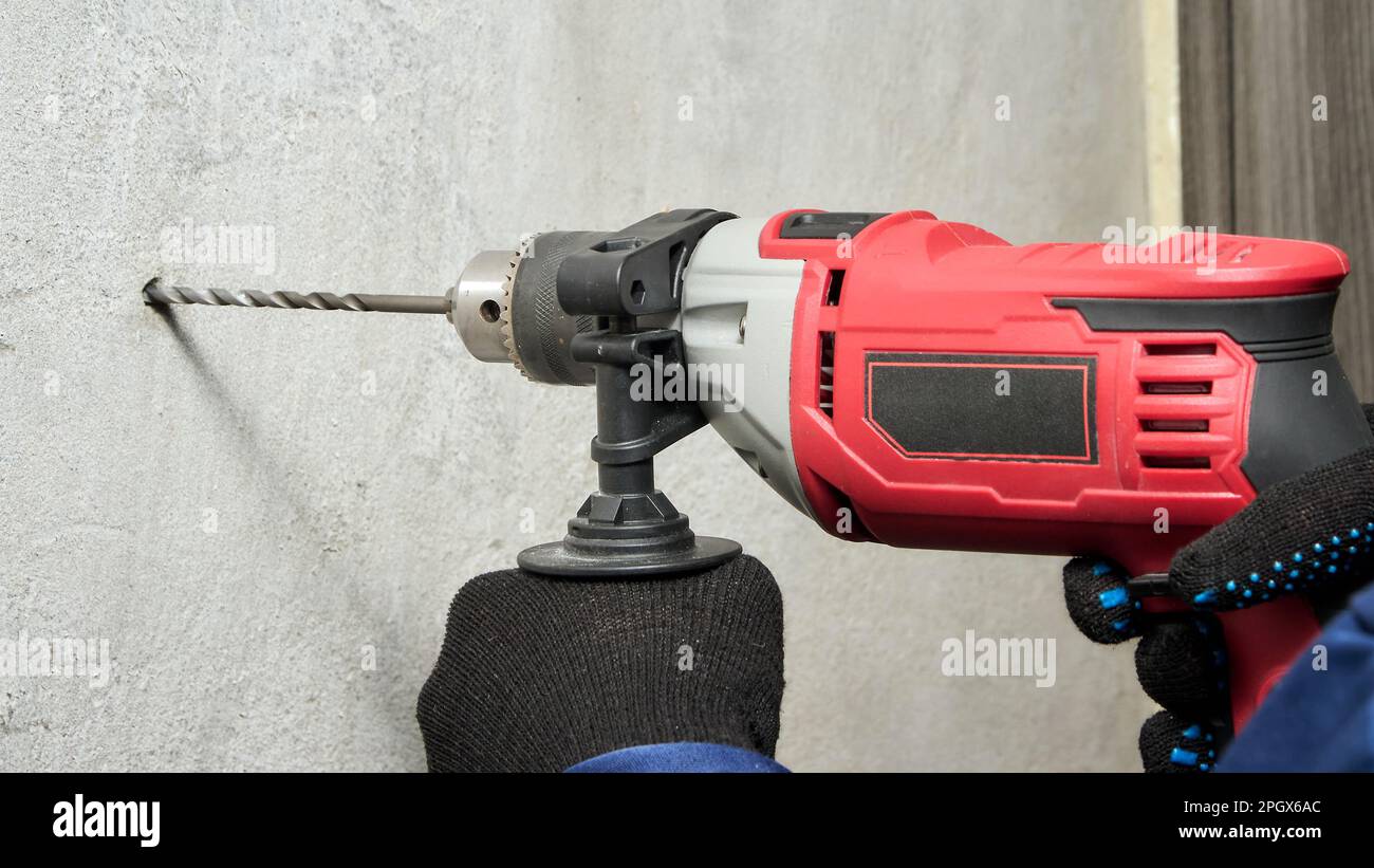 Drilling a hole in the wall with a drill Stock Photo Alamy