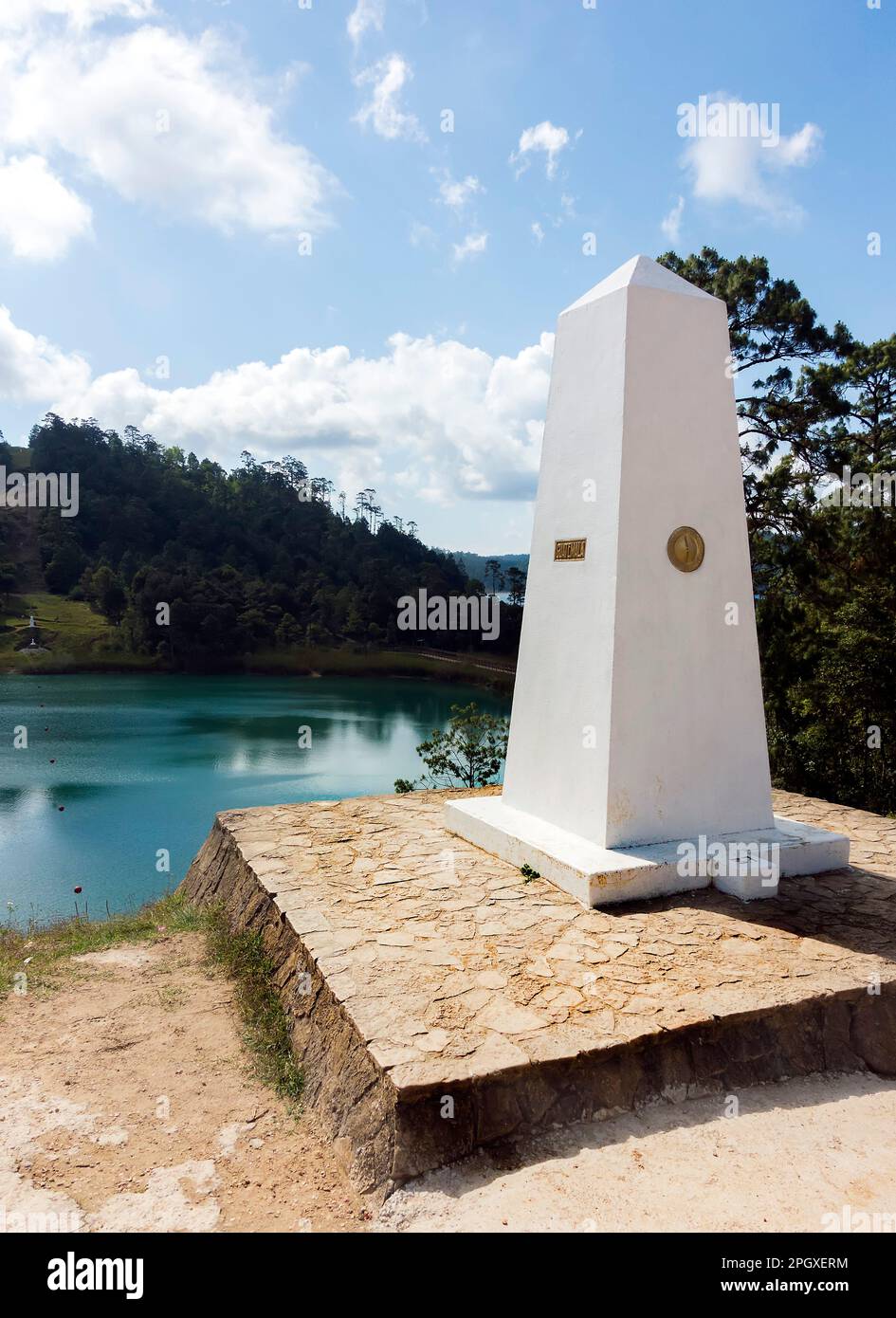 Stone obelIsk on land and buoyed line across a lake marks the border between Guatamala and Mexico Stock Photo