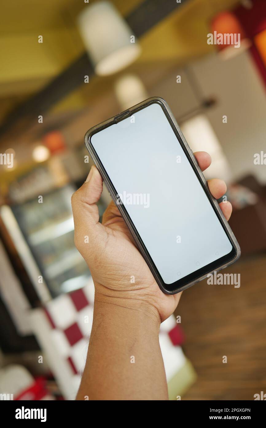 young man hand using smart phone with green screen at cafe Stock Photo ...