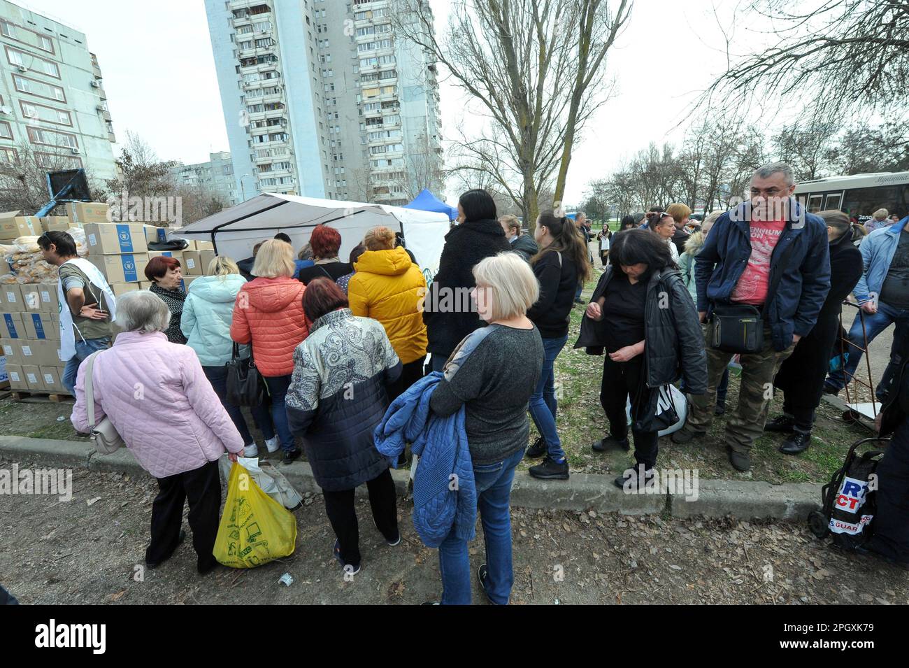 ZAPORIZHZHIA, UKRAINE - MARCH 24, 2023 - Residents of the nine-story buildings damaged by the Russian rocket fire stand in line for humanitarian aid, Zaporizhzhia, southeastern Ukraine. Stock Photo