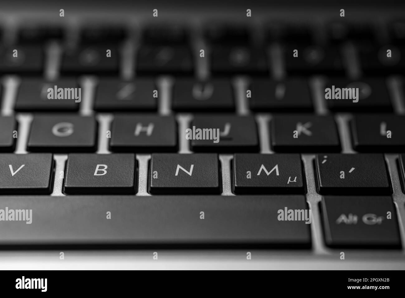 closeup of a laptop keyboard with black keys and a silver case Stock Photo
