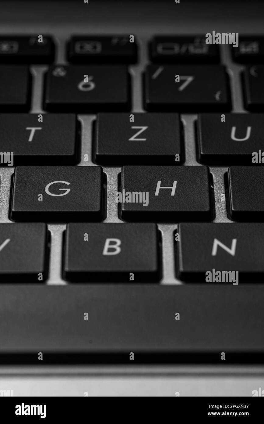 closeup of a laptop keyboard with black keys and a silver case Stock Photo