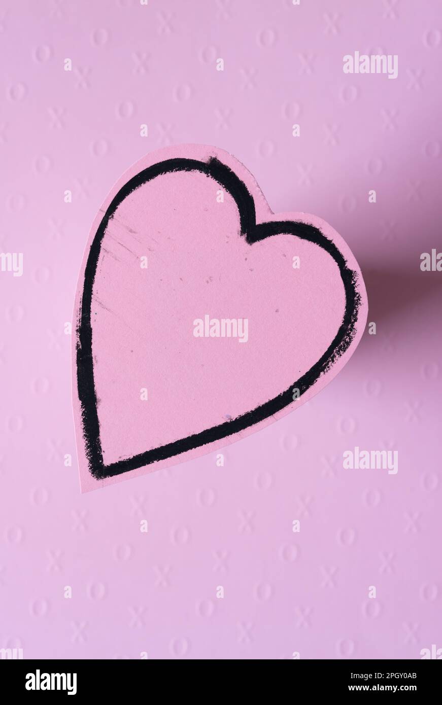 isolated pink paper heart with a black pastel border raised slightly with 3d quality and shadow Stock Photo