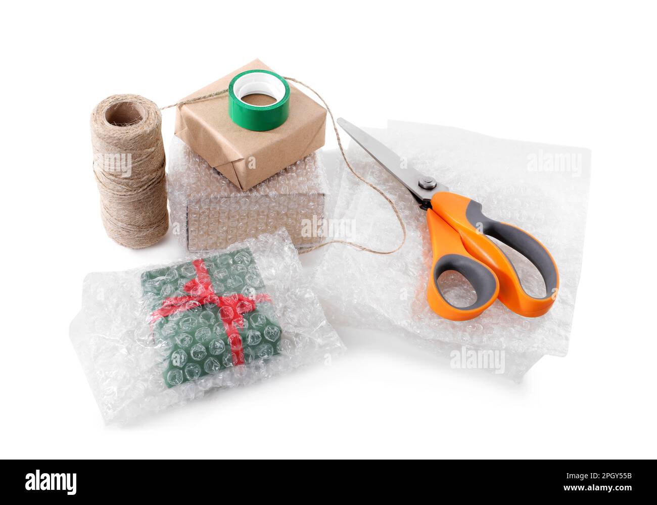 Cardboard boxes, bubble wrap, scissors and adhesive tape on white