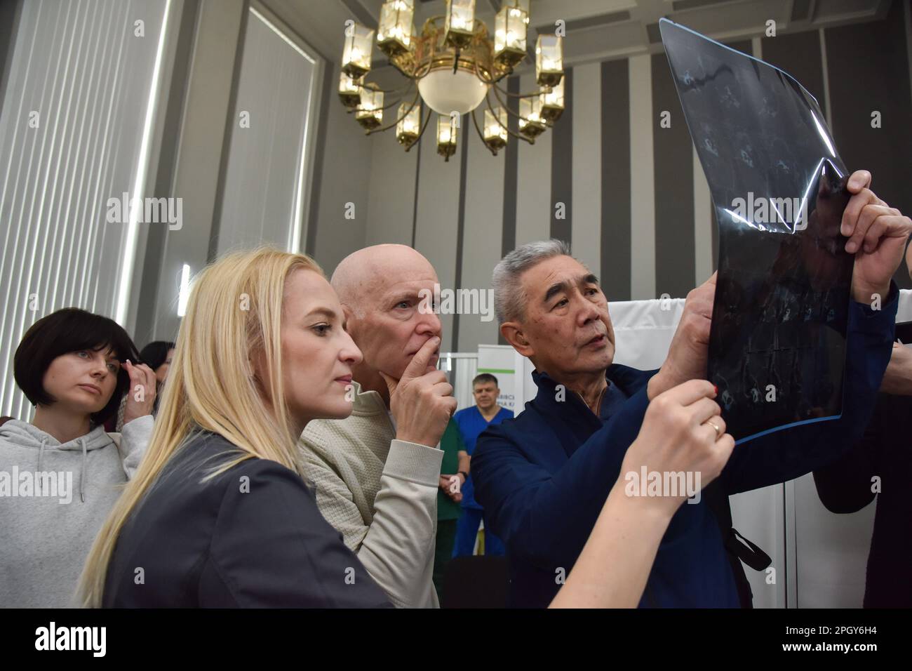 Lviv, Ukraine. 20th Mar, 2023. American surgeons examine an Xray of a