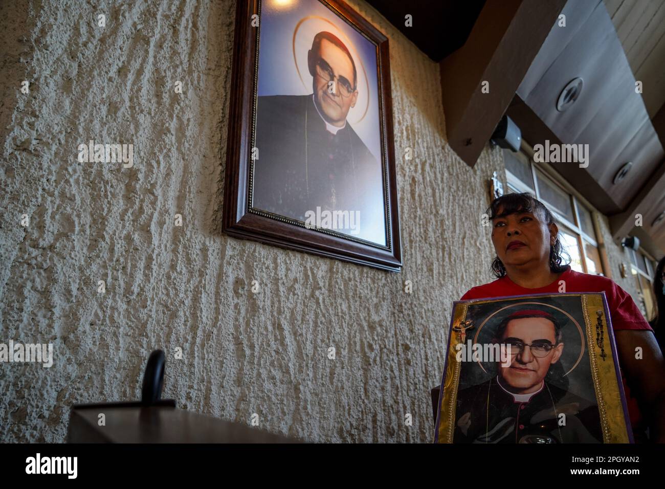 San Salvador, El Salvador. 24th Mar, 2023. A reveler holds an image depicting Saint Oscar Arnulfo Romero. On March 24th 1980 Archbishop Oscar Romero was assassinated by death squads while giving mass at the Divina Providencia chapel. Credit: SOPA Images Limited/Alamy Live News Stock Photo