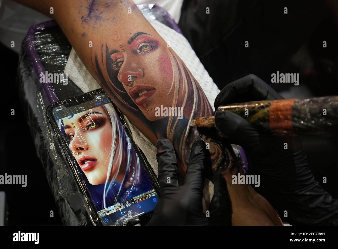 Laura Egea tattoos an image of a woman on the arm of Juan de la