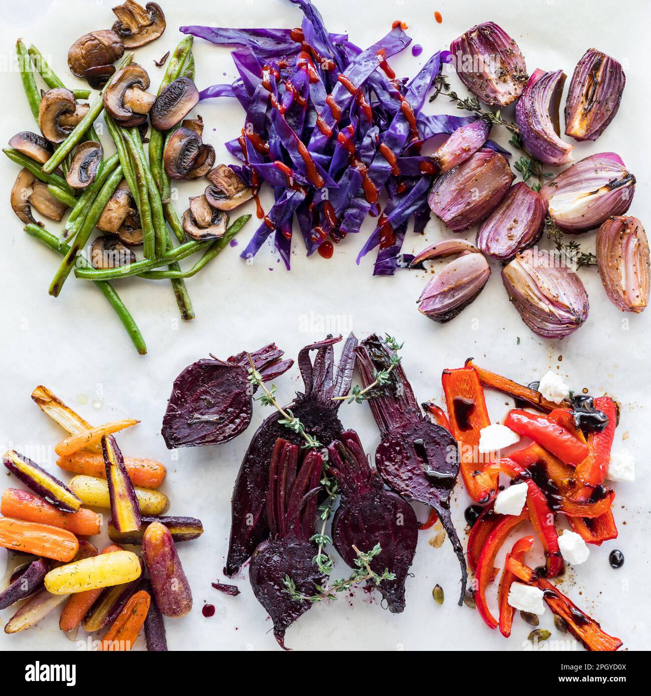 Top down view of groups of steamed or roasted vegetables on parchment