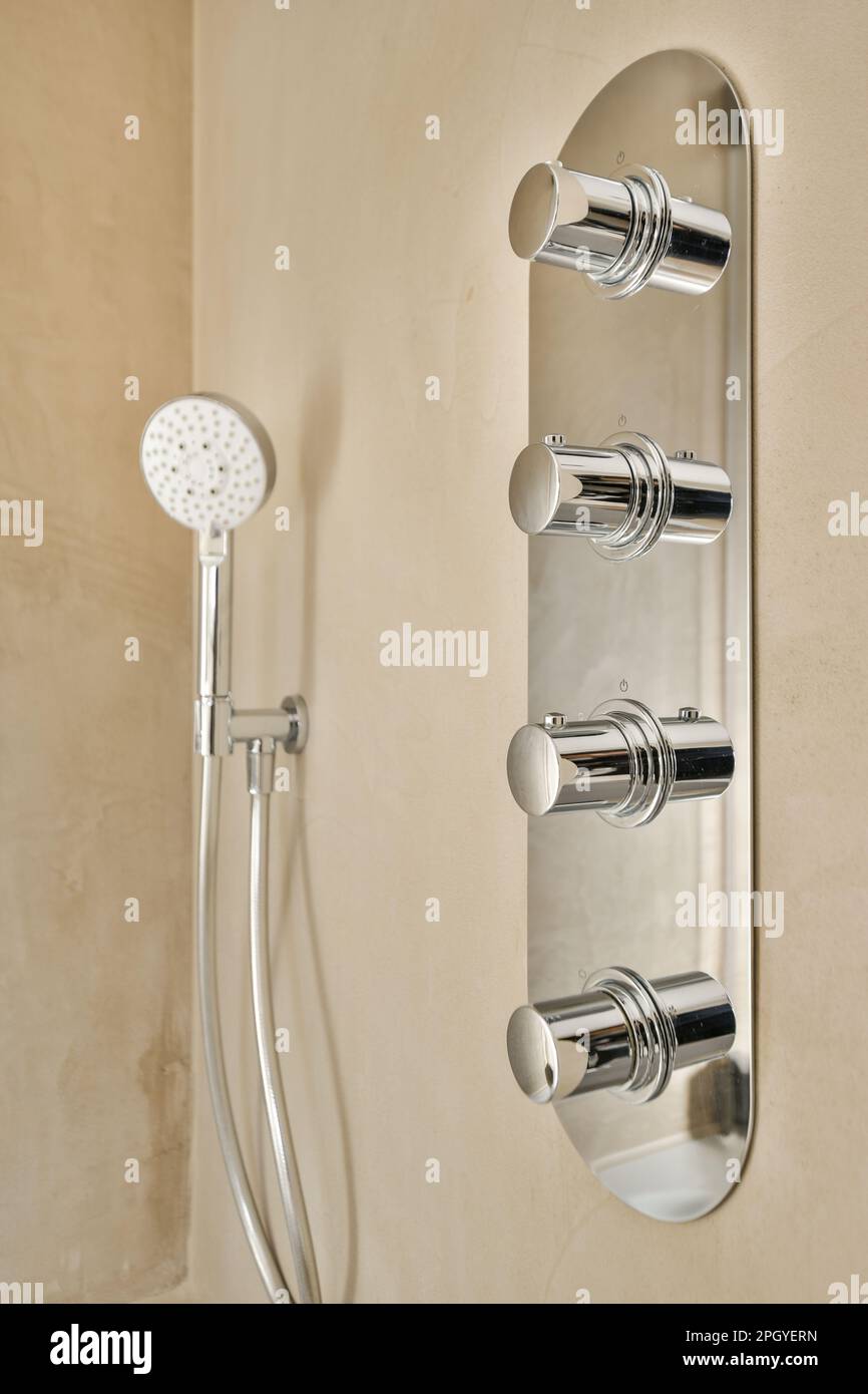 a wall mounted shower with two handsets and an overhead hand showerhead