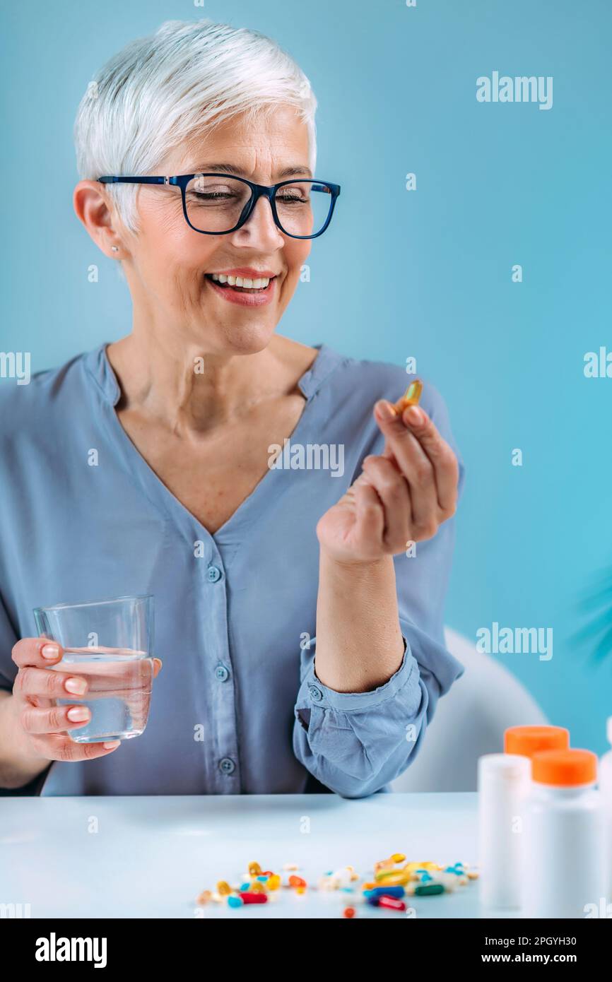 Senior woman taking dietary supplement Stock Photo