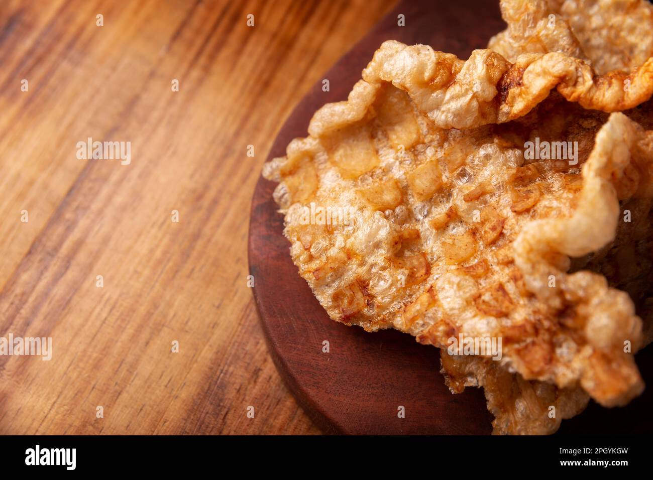 Chicharron. Crispy Fried pork rind, are pieces of aired and fried pork skin, traditional Mexican ingredient or snack served with lime juice and red ho Stock Photo