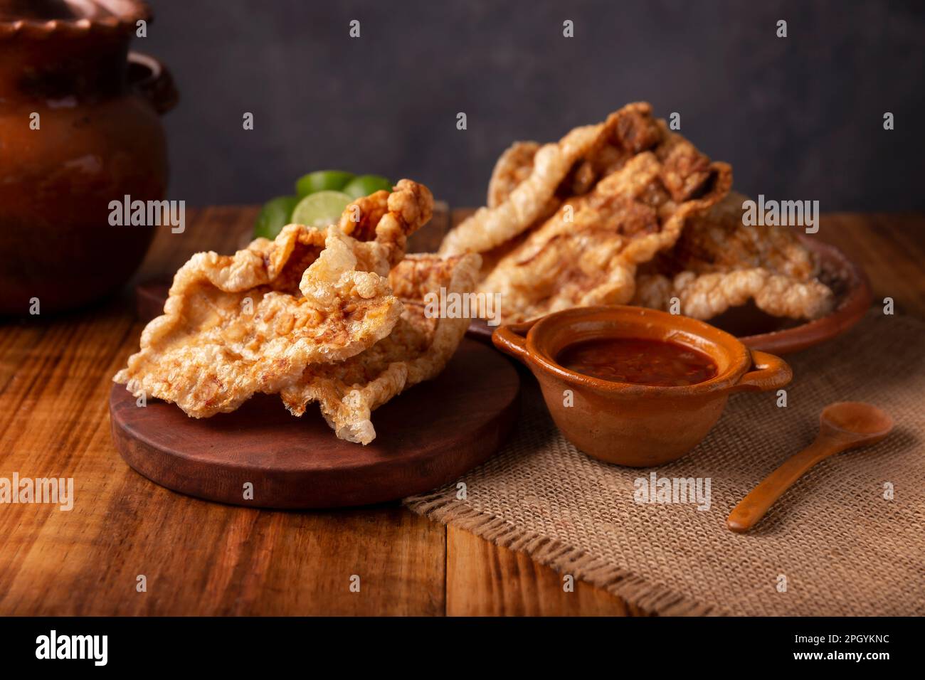 Chicharron. Crispy Fried pork rind, are pieces of aired and fried pork skin, traditional Mexican ingredient or snack served with lime juice and red ho Stock Photo
