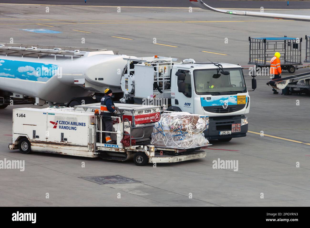 PRAGUE, CZECHIA, JAN 19 2023, A Mobile cargo transporter beside a truck with fuel cistern at an international airport Stock Photo