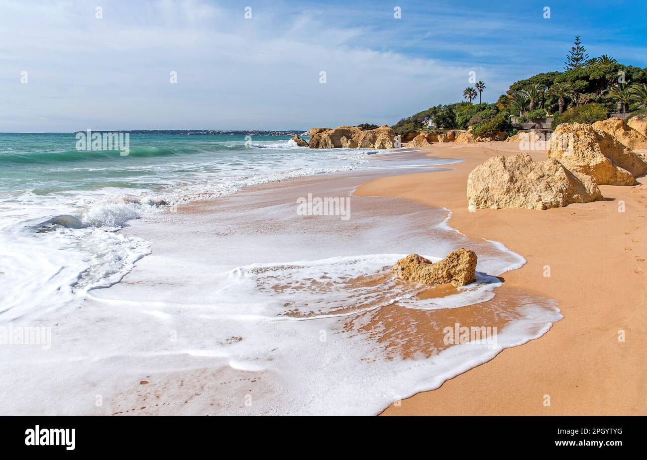 Atlantic waves roll ashore at deserted Praia da Galé beach near Albufeira, Algarve Portugal Stock Photo