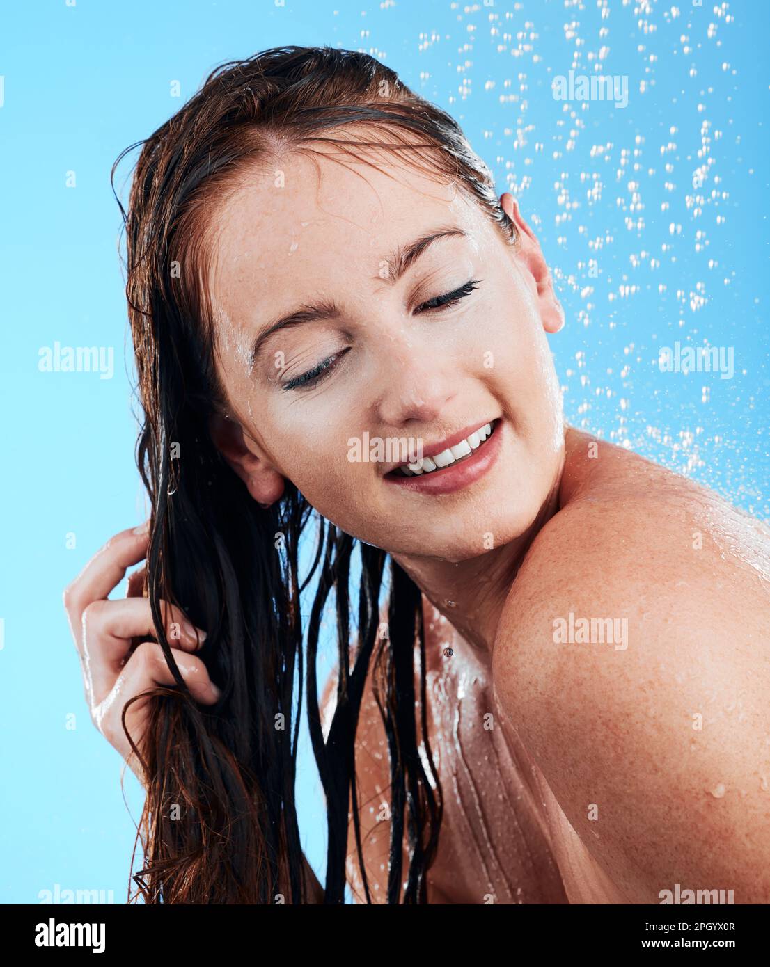 Shower hair care, water and woman in a studio feeling happy from cleaning and skincare. Wellness