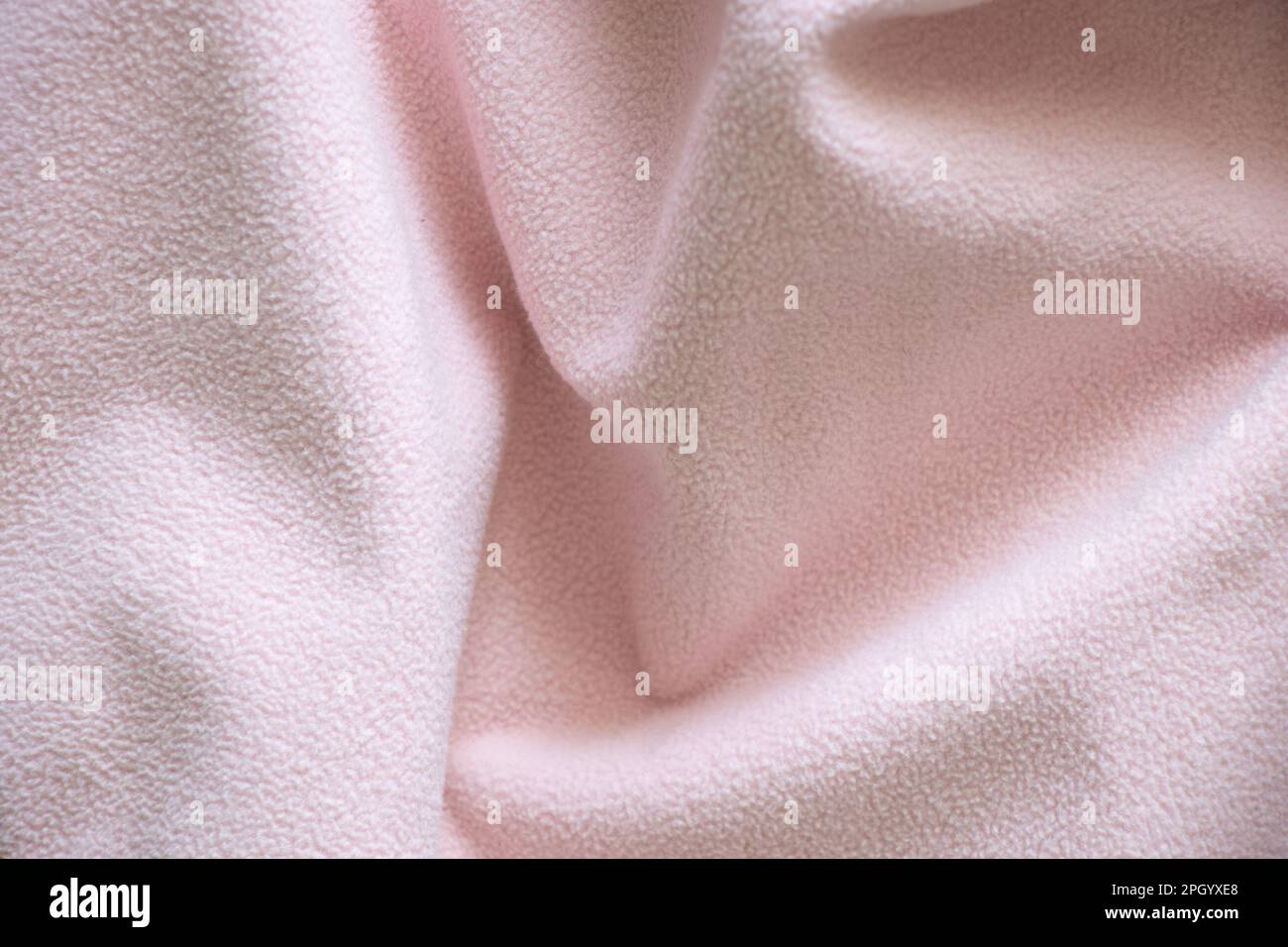 pale pink fleecy wrinkled fabric as a background close-up Stock Photo