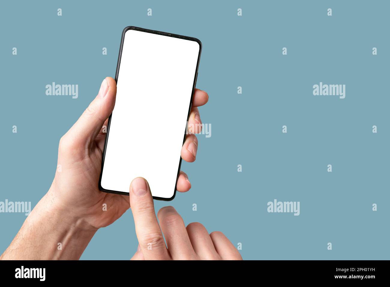 Mobile phone mock-up, finger touching, pointing on smartphone screen, display mockup in hand on blue background. Stock Photo