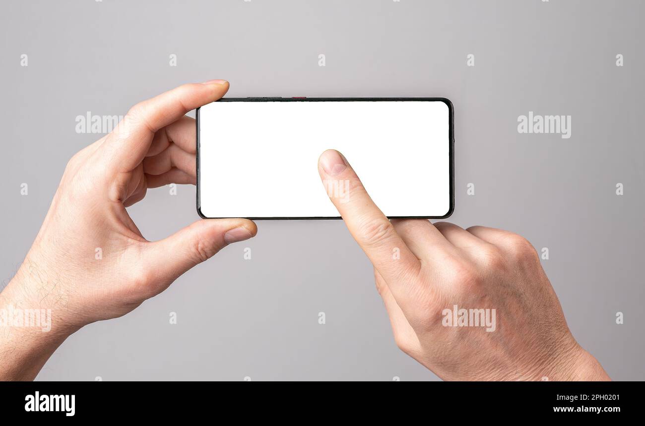 Mobile phone mock-up, Hands holding cellphone, tapping, clicking play on blank smartphone screen mockup frame. Stock Photo