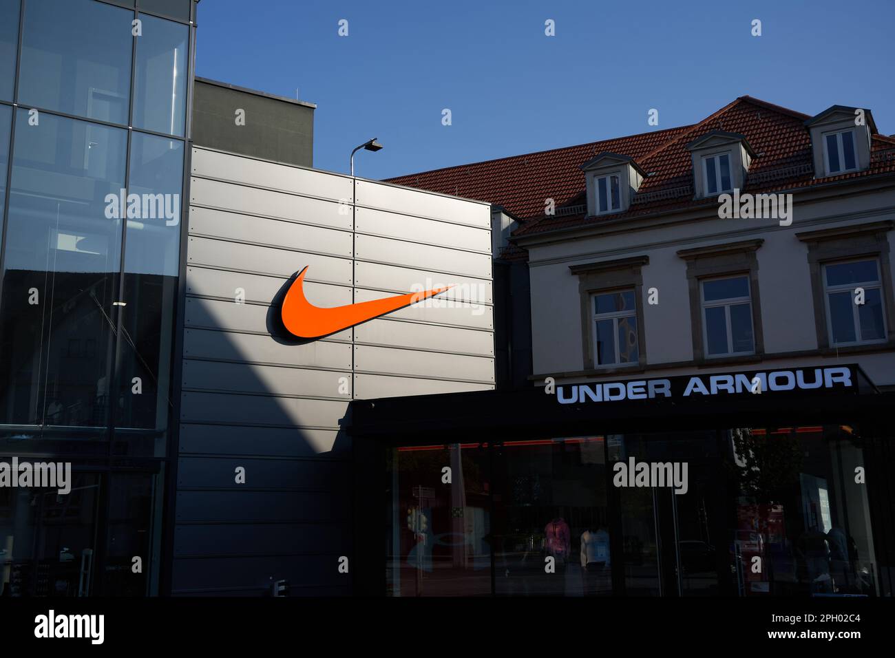 Metzingen, Germany - Mai 03, 2021: Nike swoosh company logo. Orange sign on  a store facade. Square with shadows and lights. Shopping in outlet city me  Stock Photo - Alamy