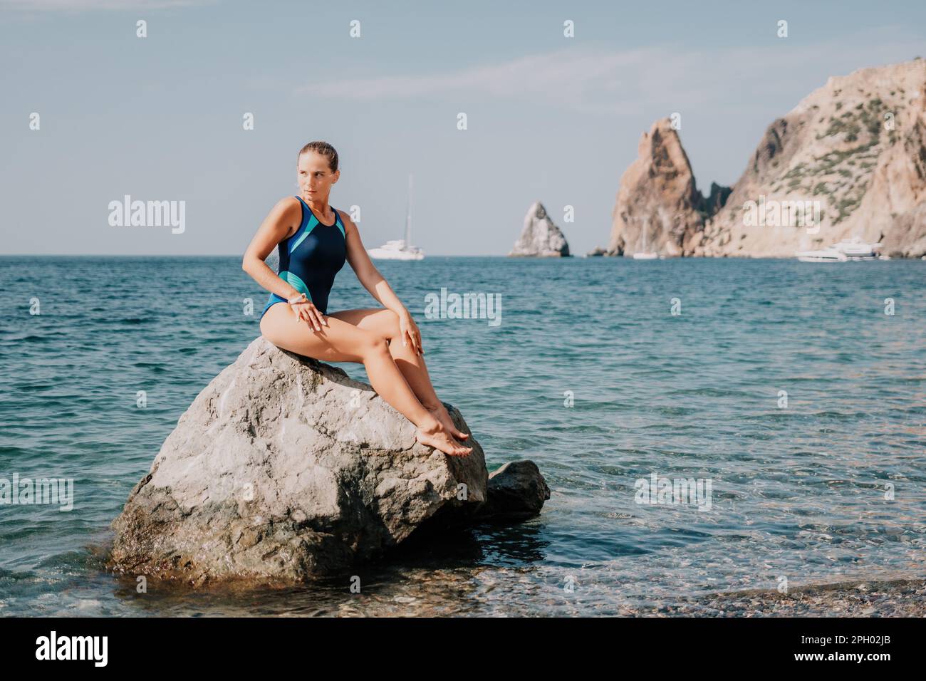 Woman travel sea. Happy tourist in blue swimwear takes a photo outdoors to capture memories. woman traveling and enjoying her surroundings on the Stock Photo