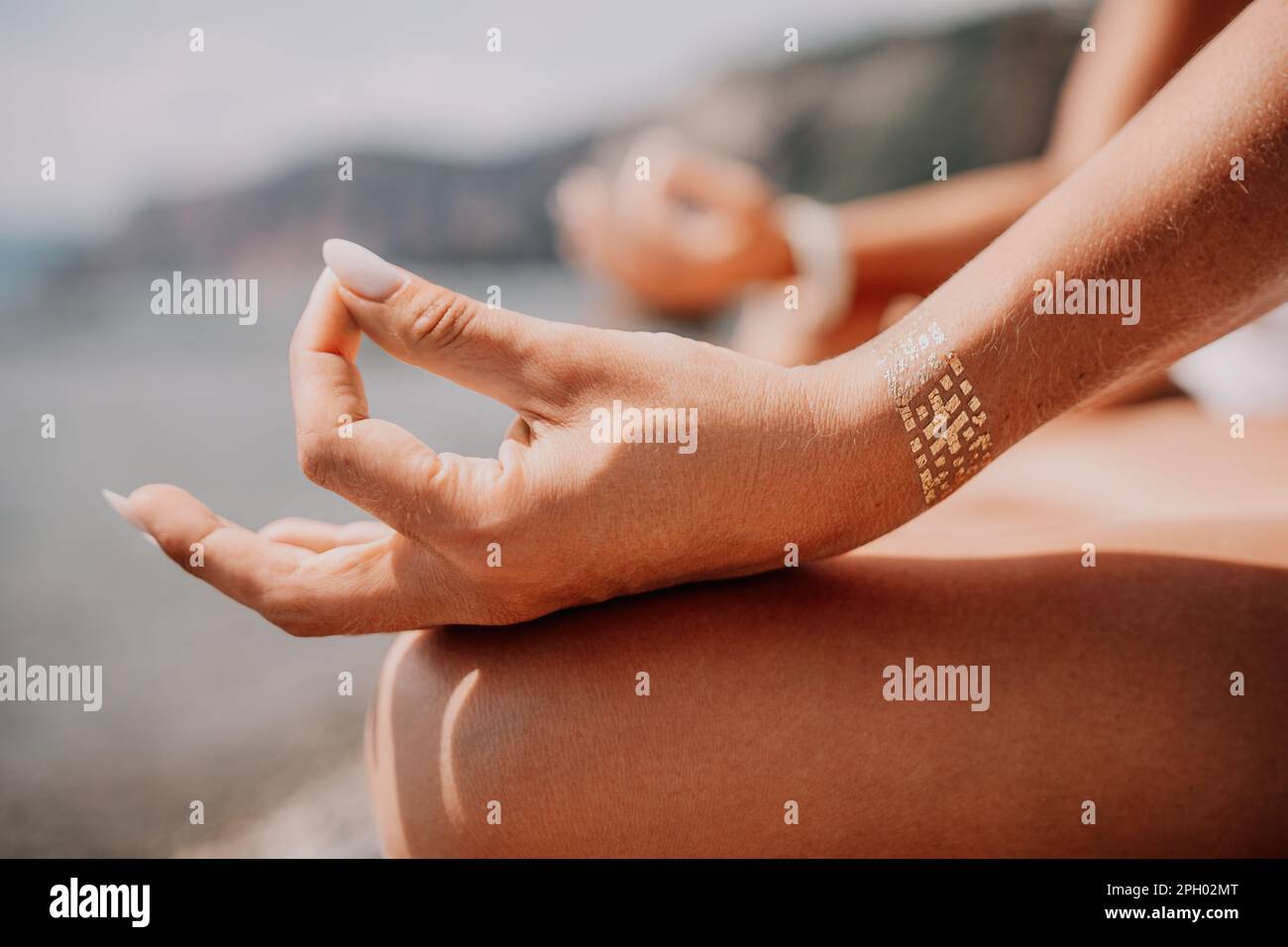 Woman sea yoga. Happy women meditating in yoga pose on the beach, ocean and rock mountains. Motivation and inspirational fit and exercising. Healthy Stock Photo