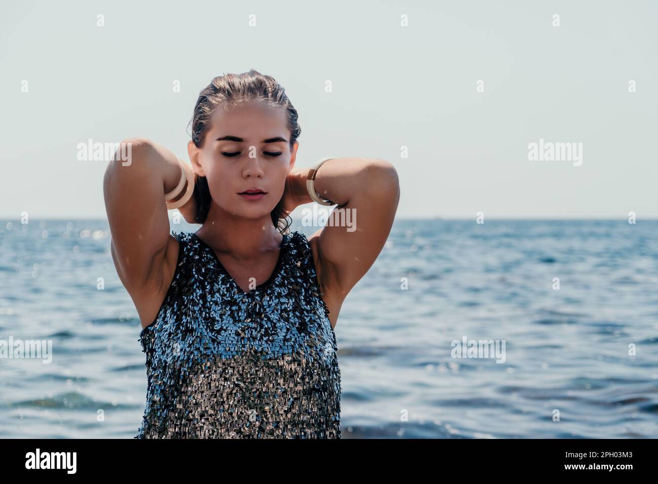 Woman summer travel sea. Happy tourist enjoy taking picture outdoors for memories. Woman traveler posing on the beach at sea surrounded by volcanic Stock Photo
